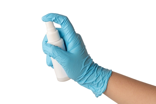 hand with medical glove spraying disinfectant